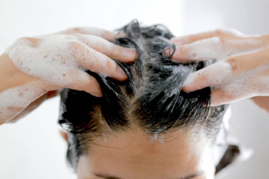Kobieta myje swoje włosy pod prysznicem
