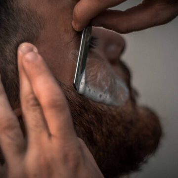 Mężczyzna podczas golenia brody u barbera