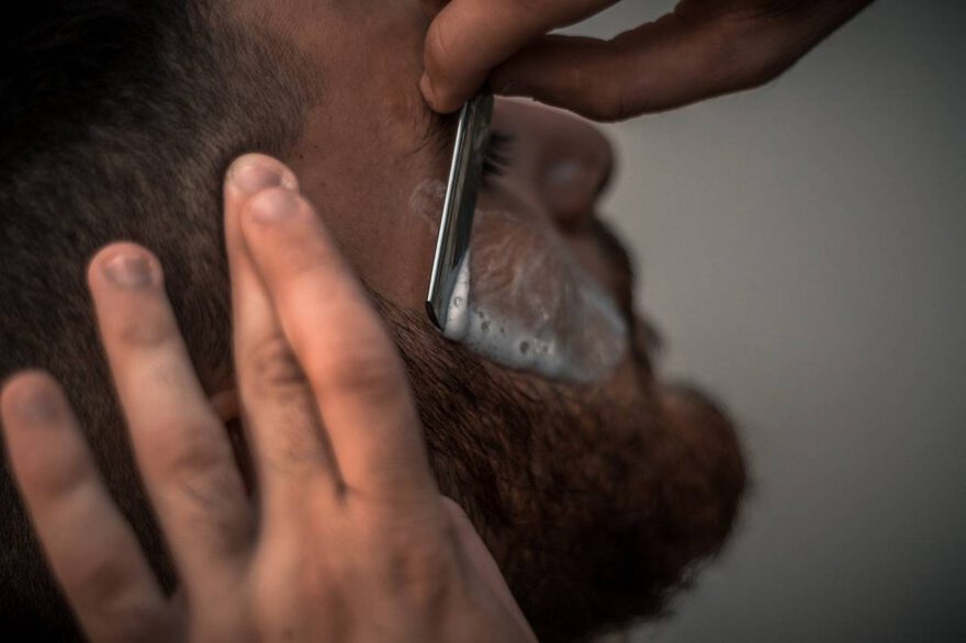Mężczyzna podczas golenia brody u barbera